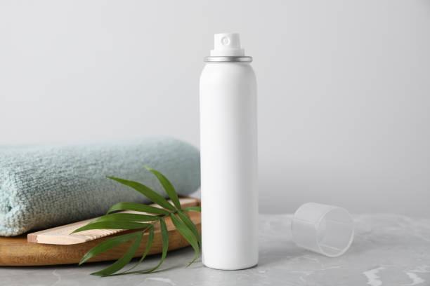 istock Dry shampoo spray, green twig and towel on light grey marble table 1469972980