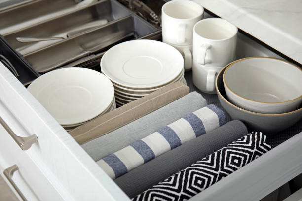 istock Open drawer of kitchen cabinet with different dishware and towels, closeup 1469973894