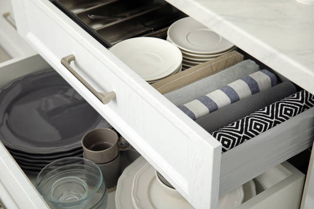 istock Open drawers of kitchen cabinet with different dishware and towels, closeup 1469973913
