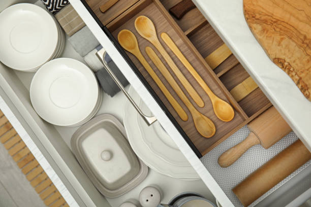 istock Open drawers of kitchen cabinet with different dishware and utensils, top view 1469973933