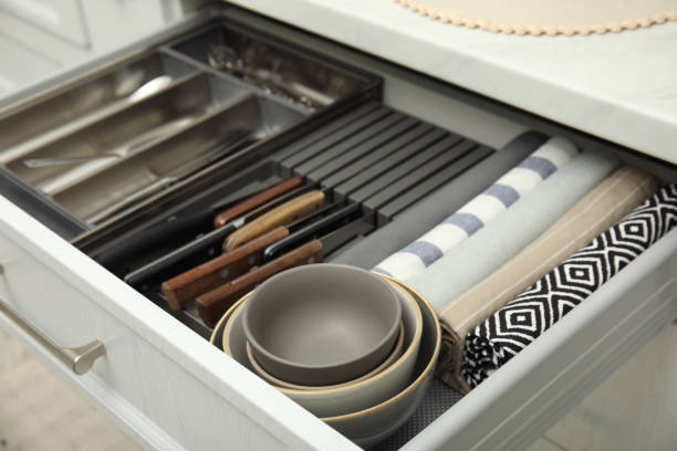 istock Open drawer of kitchen cabinet with different utensils, dishware and towels, closeup 1469974063
