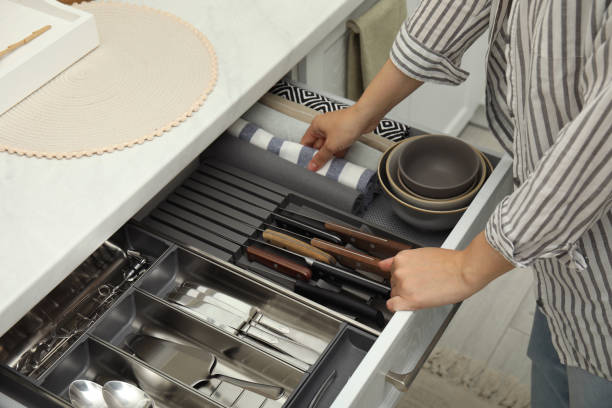 mulher que toma a toalha da gaveta aberta do armário da cozinha, closeup - home interior women domestic kitchen cabinet - fotografias e filmes do acervo