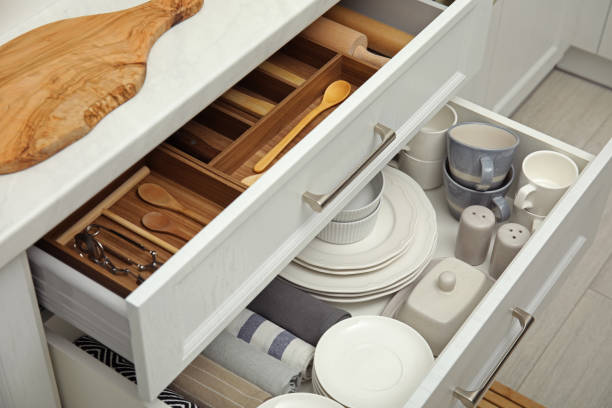 istock Open drawers of kitchen cabinet with different dishware, utensils and towels 1469976001