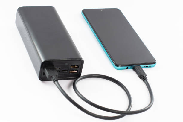 istock power bank with charging cable and phone, copy space and white background. 1469977505