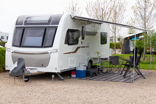 Touring caravan parked on caravan site and set up with chairs and leisure equipment, ready to enjoy a break and relaxation in a home  from home.