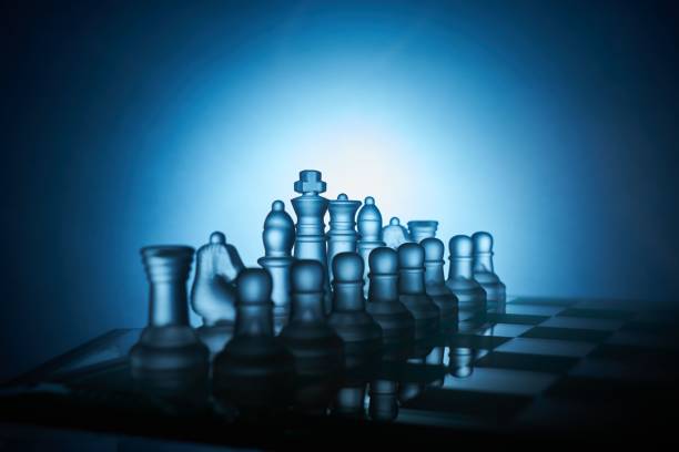 istock Chess board and transparent chess figures with blue and black background in close up. 1469978814