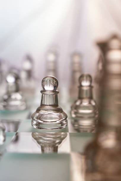istock Transparent chess figures on a chess board with blurred chess figures in the background. 1469978826