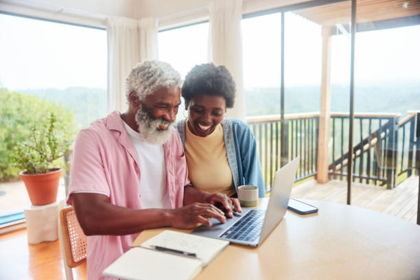 istock Smiling couple doing their finances on a laptop at home 1469979709