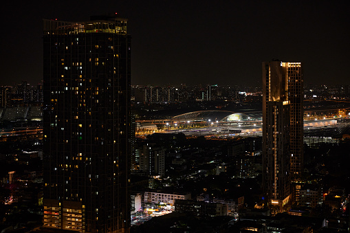 High-rise buildings and the Bangkok skyline at night with glowing lights, photographed in high resolution