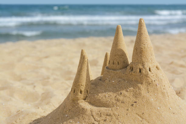 istock Beach with sand castle near sea on sunny day. Space for text 1469981994