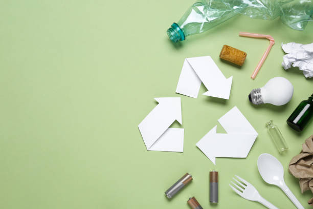 istock Recycling symbol and garbage on light green background, flat lay. Space for text 1469982234