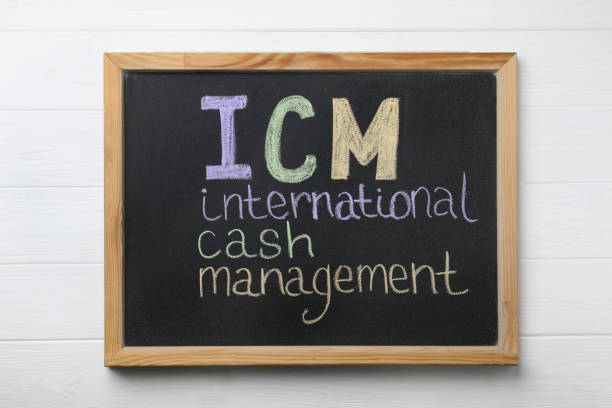 istock Small blackboard with abbreviation ICM (International Cash Management) on white wooden background, top view 1469982464