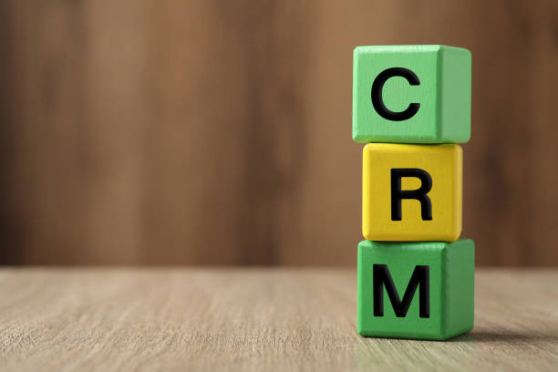 istock Abbreviation CRM of cubes on wooden table, space for text. Customer Relationship Management 1469982684