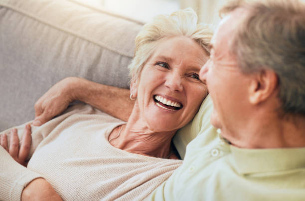 istock Love, smile and relax with old couple on sofa for affectionate, bonding and happiness. Retirement, trust and marriage with man and woman in living room of home for support, quality time and peace 1469984080