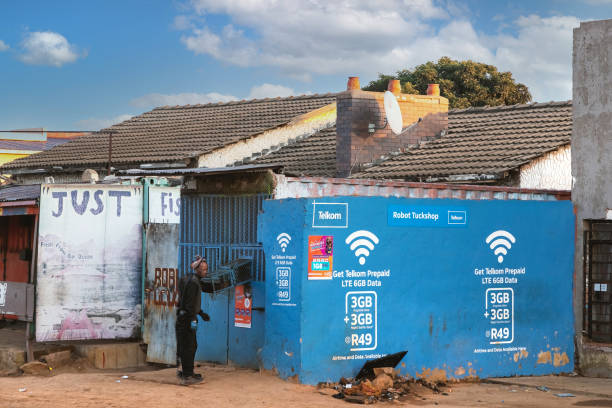 Johannesburg, South Africa, 16th July - 2022: Man buys prepaid airtime for mobile phone from heavily fortified shop in township.