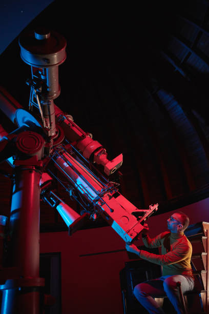 istock Astronomer with a big astronomical telescope in observatory doing science research of space and celestial objects. 1469985748