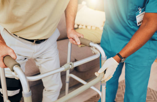 istock Disability, nurse and senior walking frame for support, help and trust moving legs, muscle healthcare or rehabilitation. Physiotherapy, elderly nursing and caregiver hands consulting disabled patient 1469986151