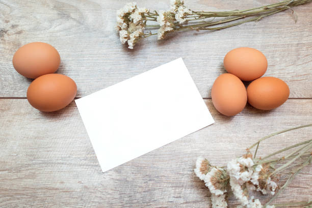 istock Easter rustic banner with copy space and a greeting card. Brown chicken eggs with white flowers on a brown background. 1469986255