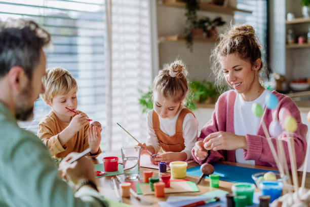 istock Happy family with little kids decorating easter eggs. 1469986277