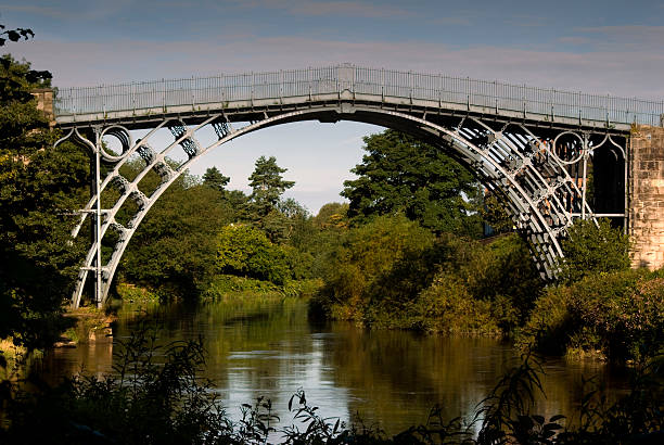 The Iron Bridge Upstream view of the first ever cast iron bridge at Ironbridge, Shropshire, England - built in 1779 by Abraham Darby III. ironbridge shropshire stock pictures, royalty-free photos & images