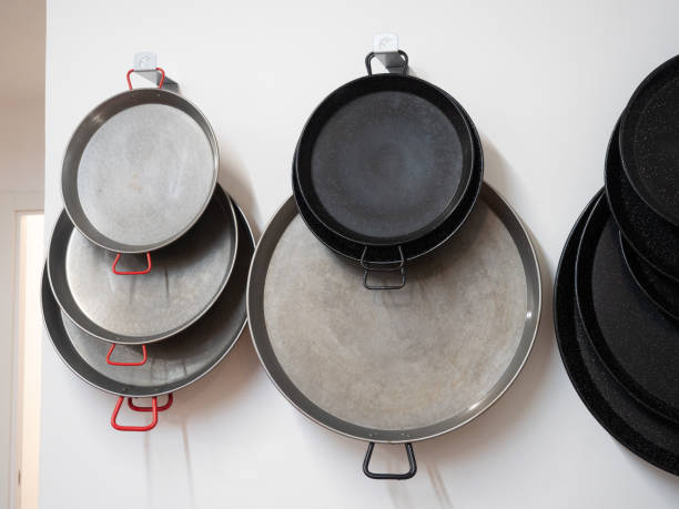 istock empty paella pans of different sizes and materials hanging on the wall. Spanish regional gastronomy. Valencia. 1469987890
