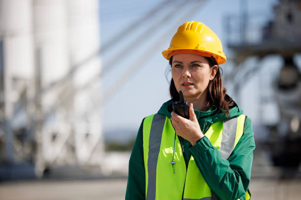 Portrait of a female engineer using walkie-talkie at industrial facility stock photo