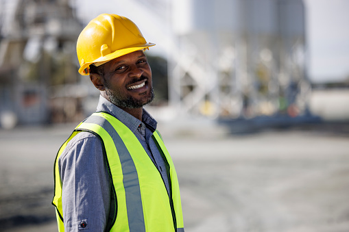 Portrait of smiling engineer with hardhat at construction site