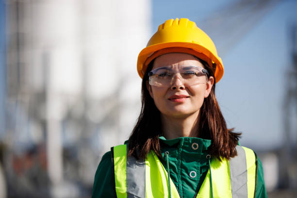 istock Smiling female engineer with hardhat and protective eyeglasses at factory industry workplace 1469987971