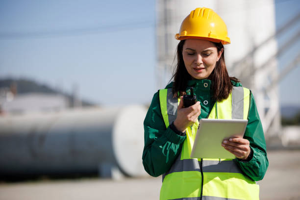 портрет женщины-инженера, использующей рацию и цифровой планшет на промышленном объекте - oil industry digital tablet manual worker mining стоковые фото и изображения
