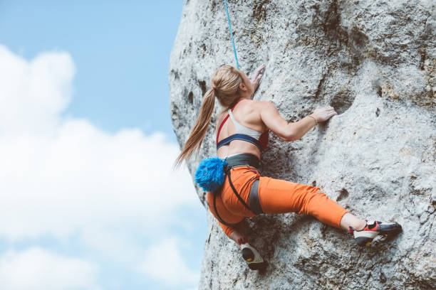 istock Athletic woman climbing on cliff rock 1469988379