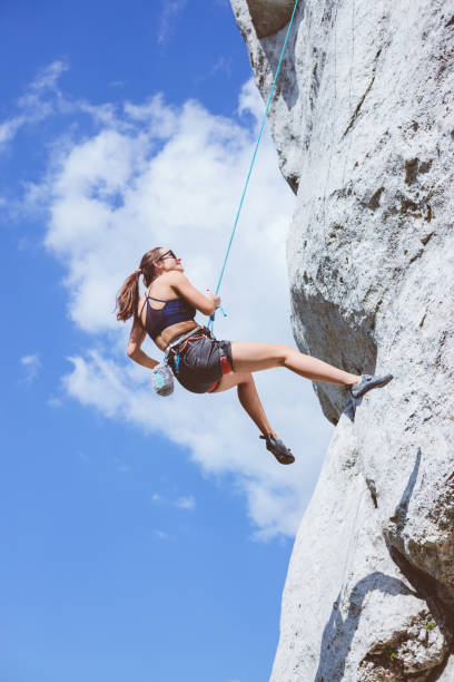 istock Young woman climbing on cliff rock 1469990581