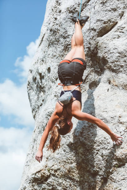 istock Young woman hanging on rope unside down while climbing 1469991510