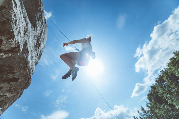 istock Young woman hanging on rope while climbing 1469991615