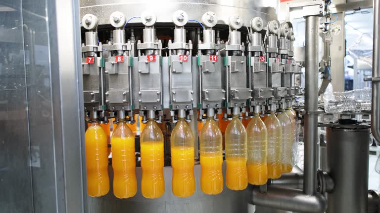 Machine filling plastic bottles with juice at the beverage factory