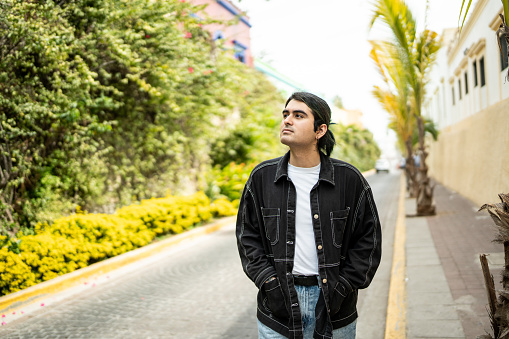 Young man walking looking away while contemplating at street