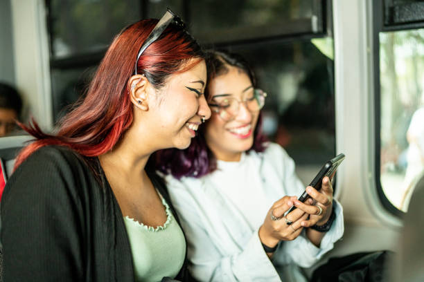 istock Young woman friends using a mobile phone on a bus 1469992290