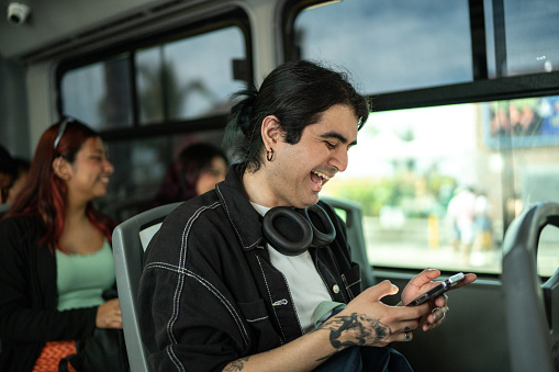 Young man using a mobile phone on a bus