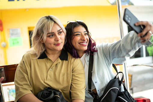 Young women taking a selfie on a open-air bus