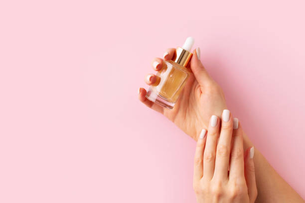 istock Womans hands with serum on pink background 1469992430