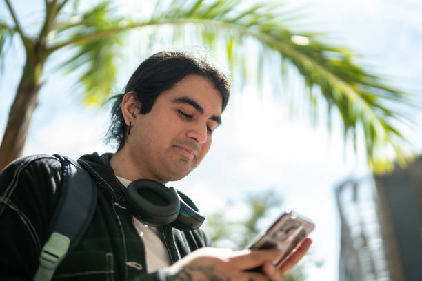 istock Young man holding a mobile phone at street 1469992431