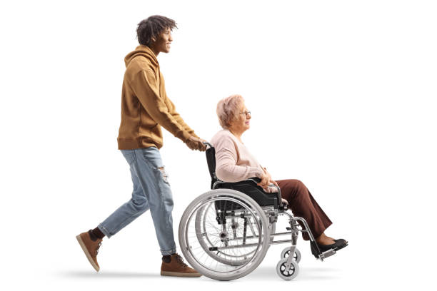 full length profile shot of an african american young man pushing an elderly woman in a wheelchair - physical injury men orthopedic equipment isolated on white imagens e fotografias de stock