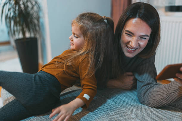 istock Smiling mother enjoying playing with her little daughter 1469993811