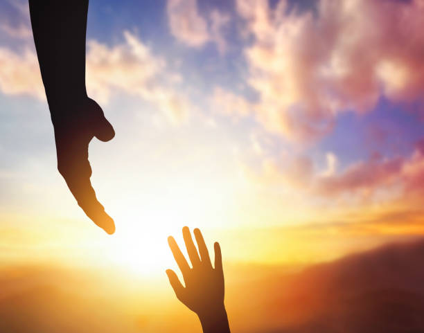 istock Silhouettes of helping hand,  hope and support each other on sunset background. 1469995384