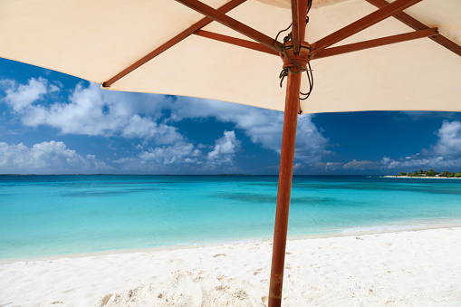 Scenic view of beach umbrella by sea against cloudy sky, Archipelago, Los Roques, Venezuela.