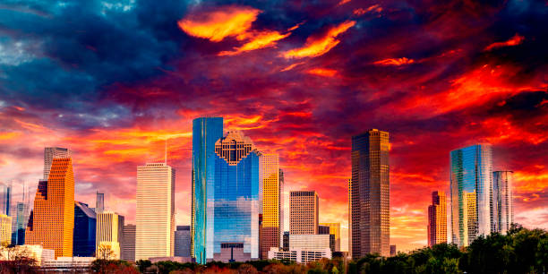 Saturated high contrast Houston Texas downtown buildings and city skyline, panoramic metropolis landscape with dramatic clouds over the public park at sunset stock photo