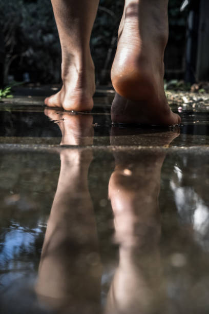 a foot steps on the wet ground.
