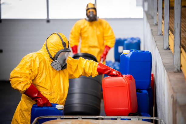 istock Warehouse workers in protection hazmat suit moving chemicals and acids. 1469997305