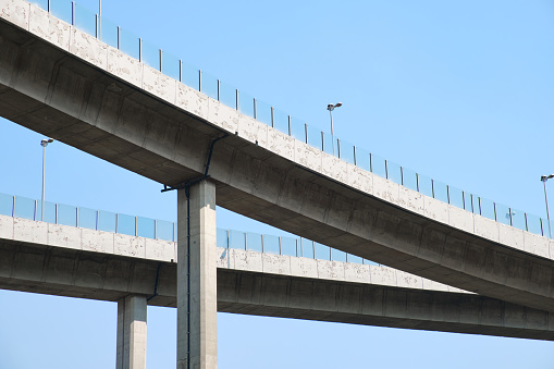 Elevated expressway during a sunny day .  highway overpass against blue sky .  Motorway viaduct interchange