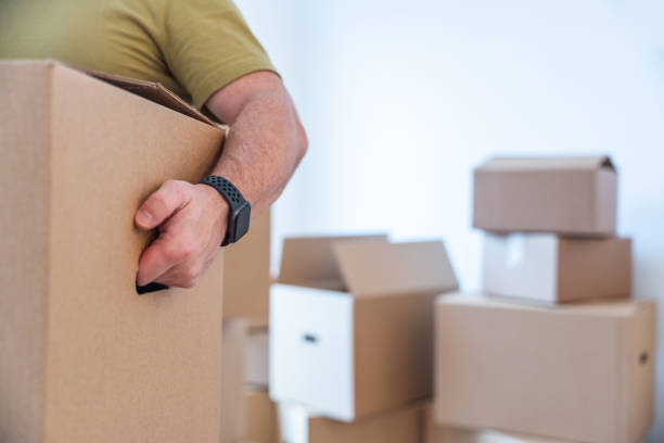 un homme transportant des boîtes en carton hors de chez lui. concept de maison de déménagement - packaging tape photos et images de collection