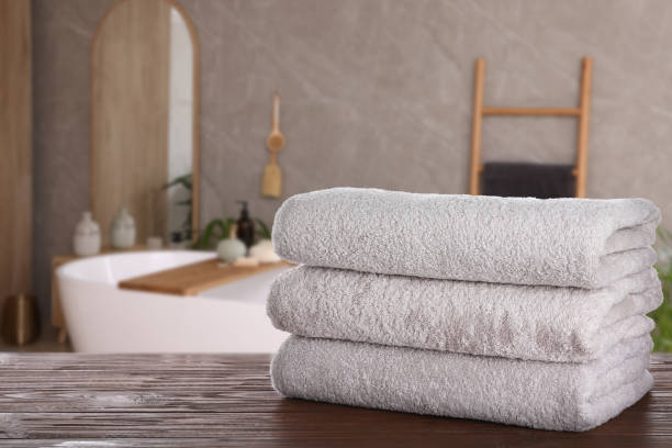 istock White clean towels on wooden table in bathroom. Space for text 1470001262